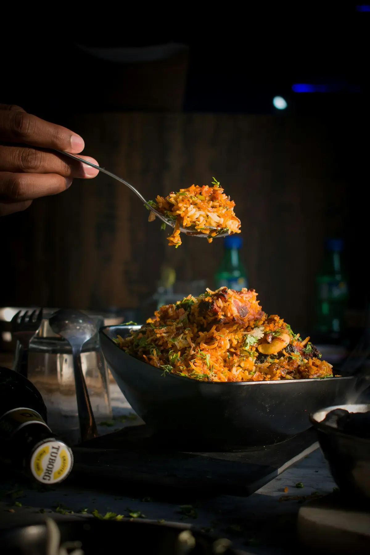 Aromatic Indian biryani being served from a dark bowl