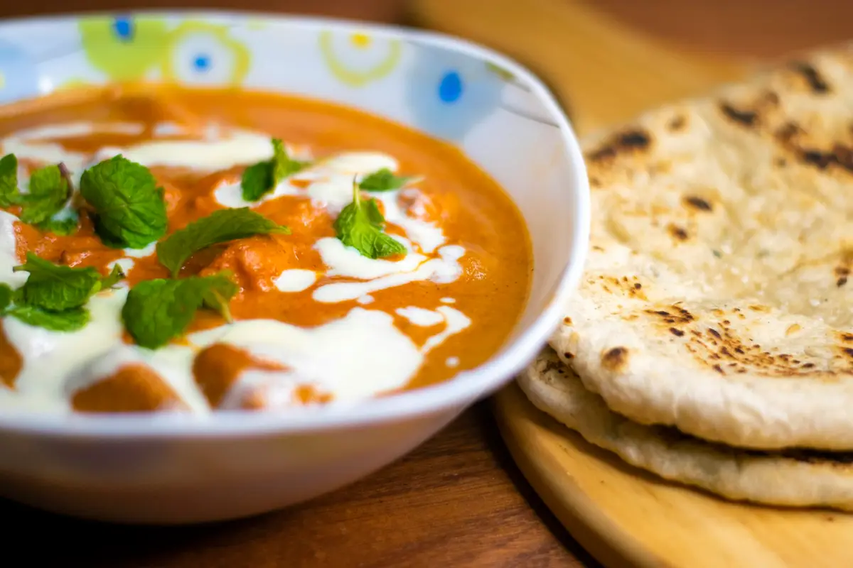 Creamy Indian curry garnished with mint and served with naan