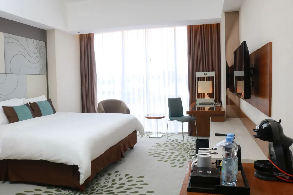 Bright, comfortable guest room representative of the Deluxe Room style